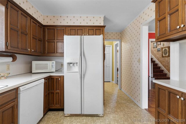 kitchen with ornamental molding and white appliances