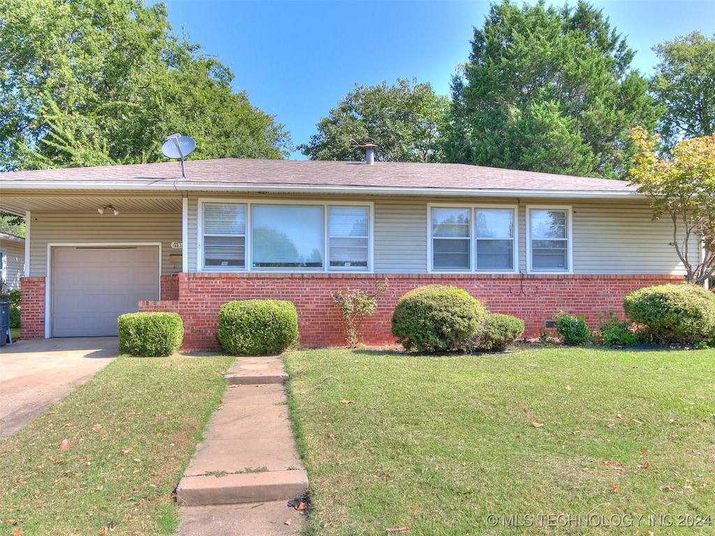 single story home featuring a garage and a front lawn