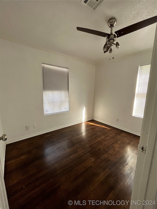 unfurnished room with dark wood-type flooring, ceiling fan, a textured ceiling, and plenty of natural light