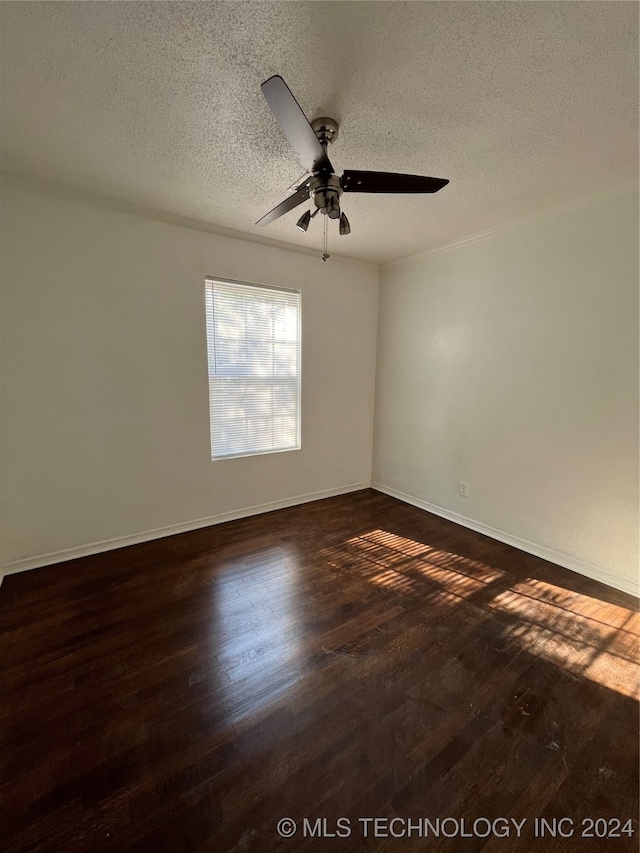 empty room featuring ceiling fan, a textured ceiling, and dark hardwood / wood-style floors