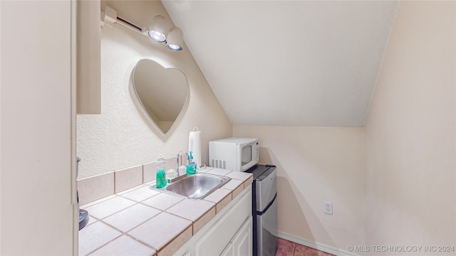 bathroom with vanity and vaulted ceiling