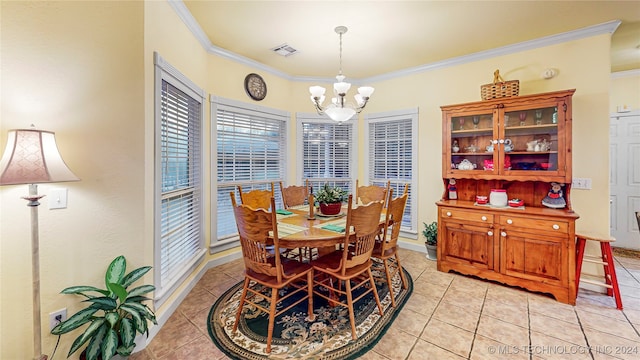 tiled dining room with an inviting chandelier and ornamental molding