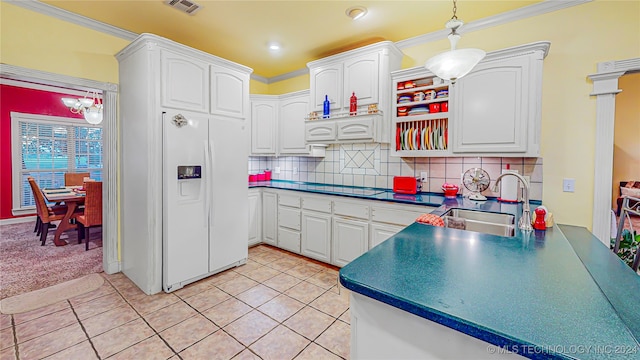 kitchen with white cabinets, backsplash, white refrigerator with ice dispenser, sink, and pendant lighting