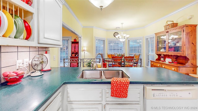 kitchen with ornamental molding, a chandelier, sink, white dishwasher, and white cabinets