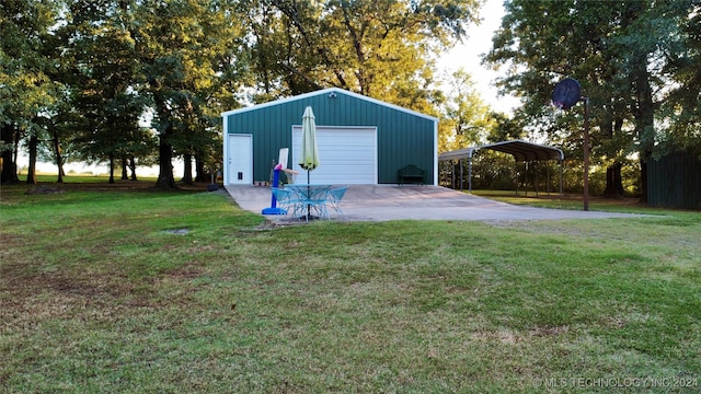 view of outdoor structure with a garage, a carport, and a lawn