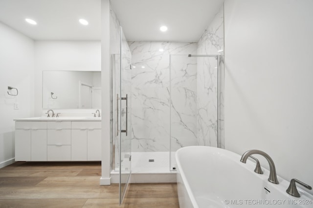 bathroom featuring independent shower and bath, vanity, and wood-type flooring