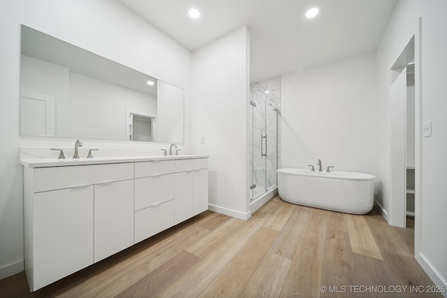 bathroom with vanity, separate shower and tub, and hardwood / wood-style floors