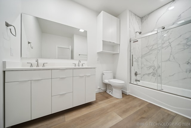 full bathroom featuring vanity, hardwood / wood-style flooring, toilet, and enclosed tub / shower combo