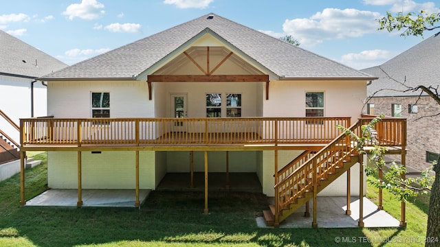 back of house featuring a lawn, a patio area, and a deck