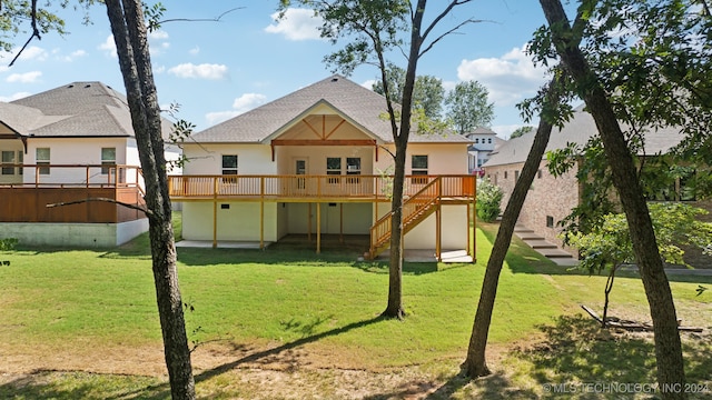 rear view of house featuring a lawn and a wooden deck