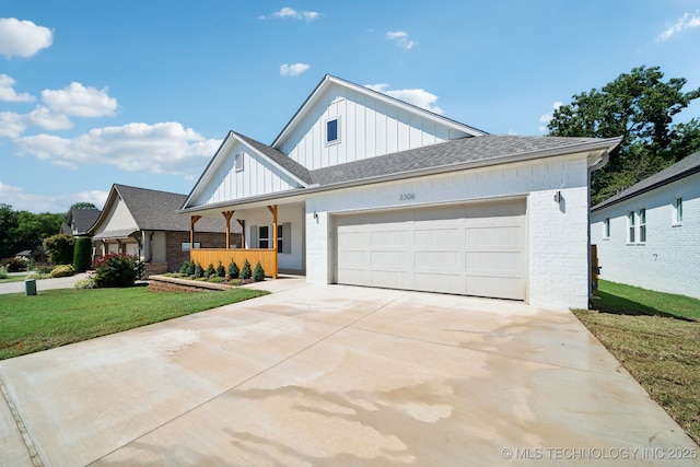 modern inspired farmhouse with a garage, covered porch, and a front lawn