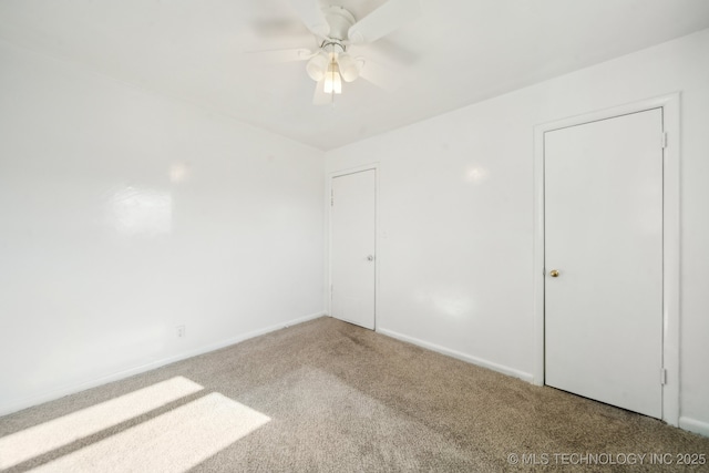 carpeted spare room featuring ceiling fan