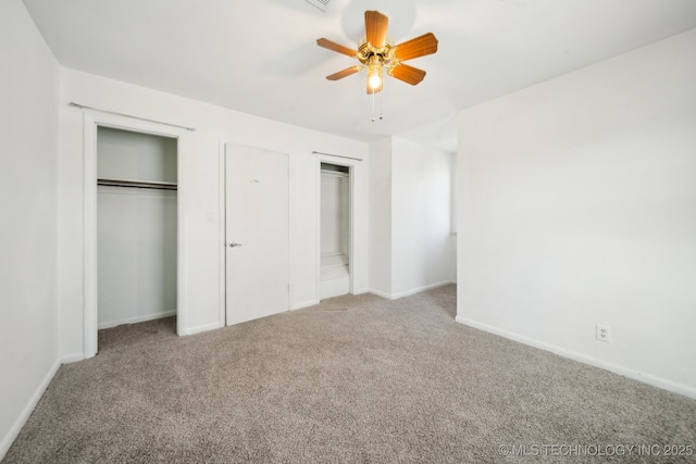 unfurnished bedroom featuring multiple closets, ceiling fan, and light carpet