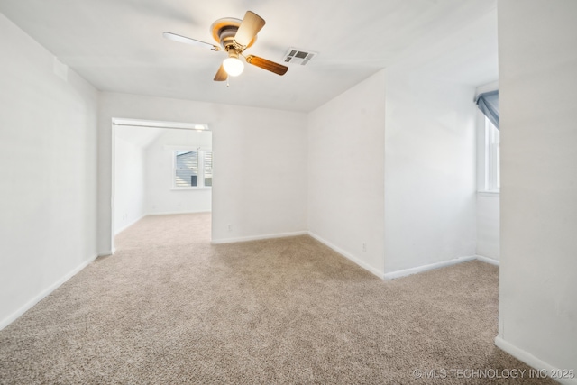 carpeted spare room featuring ceiling fan and a healthy amount of sunlight