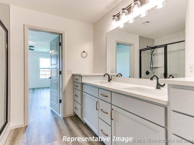 bathroom with vanity, hardwood / wood-style floors, and an enclosed shower