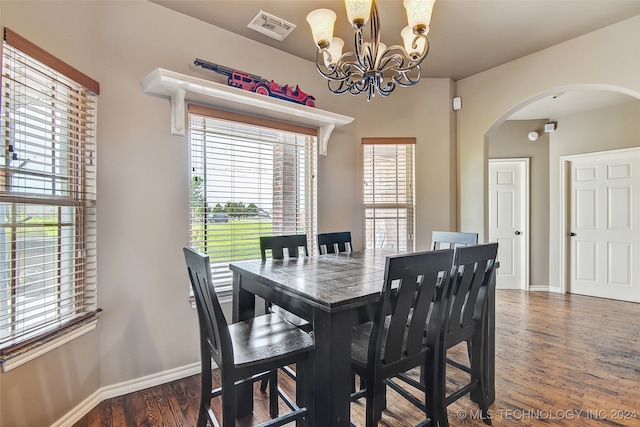 dining space featuring dark hardwood / wood-style floors and an inviting chandelier