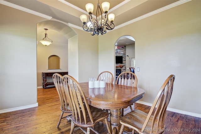 dining space with hardwood / wood-style flooring, ornamental molding, and a chandelier