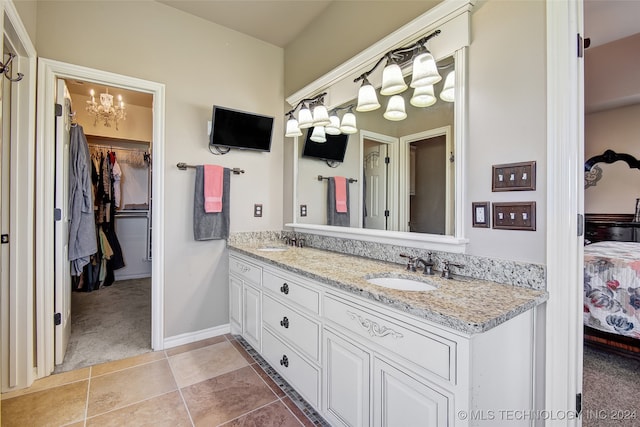 bathroom with a chandelier, vanity, and tile patterned floors