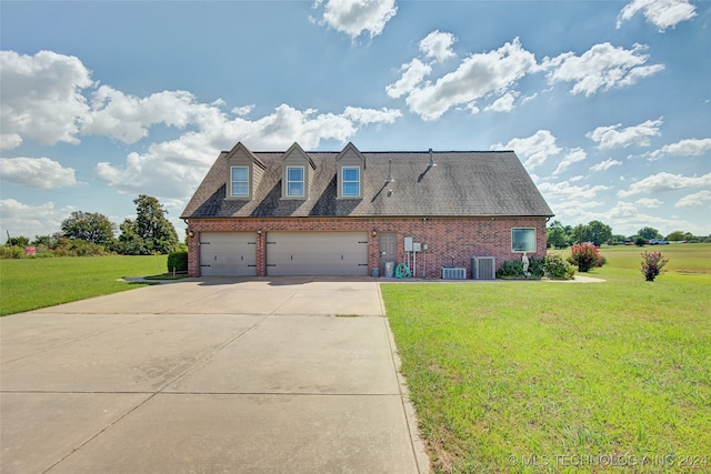 view of side of property featuring a lawn, cooling unit, and a garage