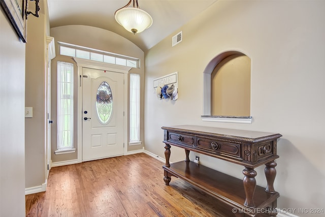 foyer entrance with lofted ceiling and hardwood / wood-style flooring