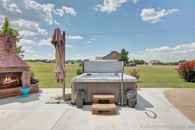 view of patio with a hot tub and an outdoor brick fireplace