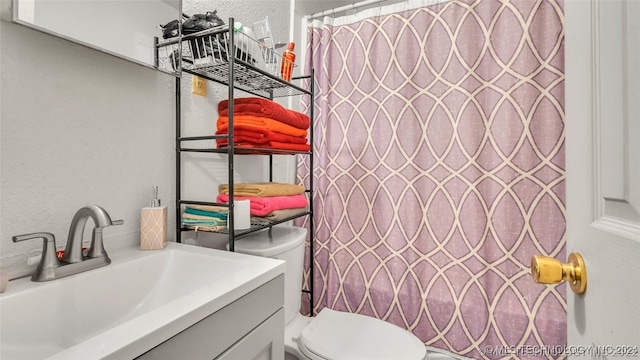 bathroom featuring walk in shower, toilet, and vanity