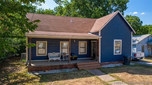 view of front of home with a porch and central AC