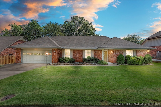 ranch-style home featuring a lawn and a garage