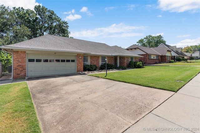 ranch-style house featuring a front yard and a garage