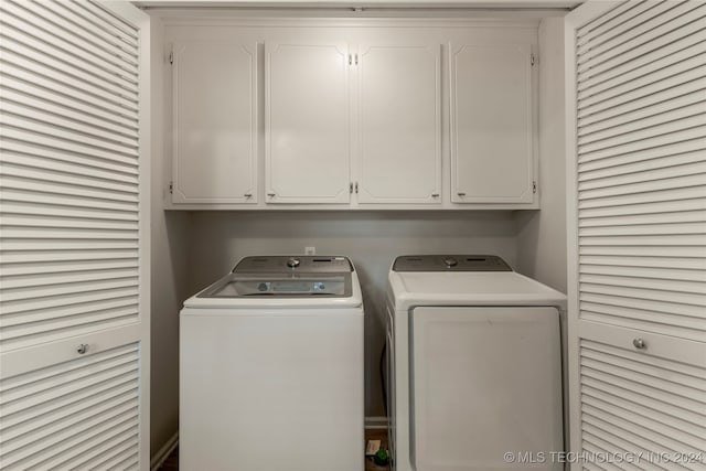 washroom with cabinets and washer and dryer