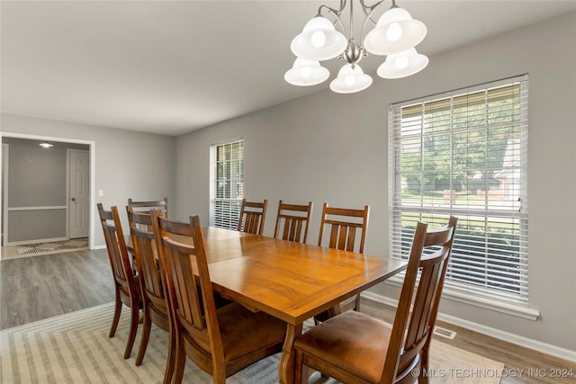 dining room featuring light wood-type flooring and a notable chandelier