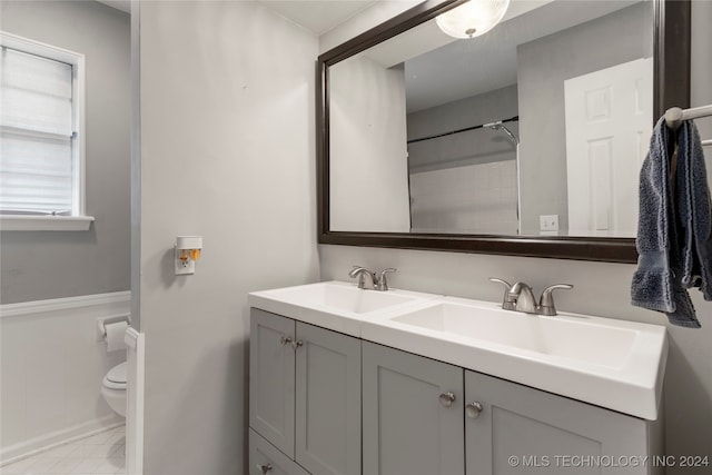 bathroom featuring a shower, vanity, and toilet