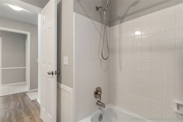 bathroom featuring tiled shower / bath combo and hardwood / wood-style flooring