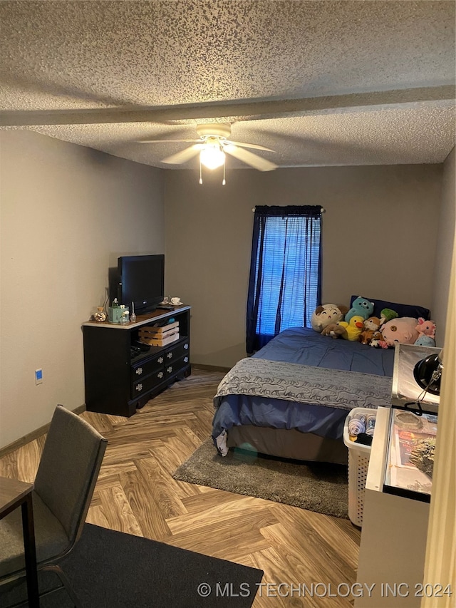 bedroom featuring parquet floors, ceiling fan, and a textured ceiling