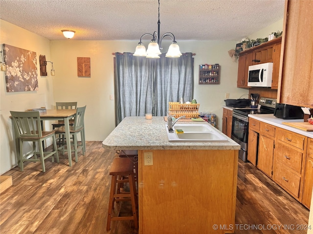 kitchen featuring sink, stainless steel range with electric stovetop, dark wood-type flooring, a kitchen island with sink, and a textured ceiling