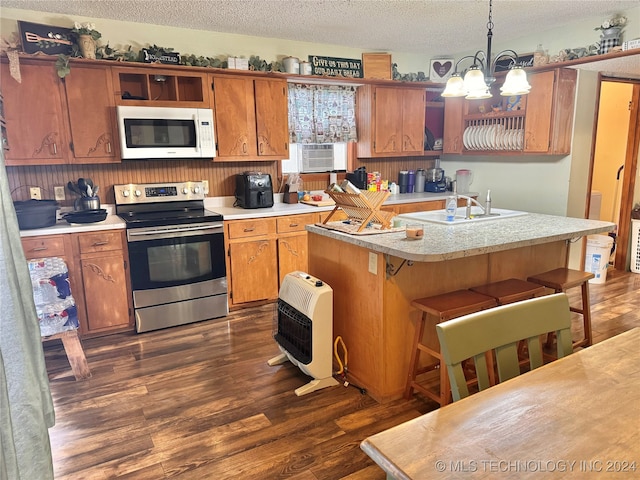 kitchen featuring pendant lighting, a notable chandelier, electric stove, a kitchen bar, and dark hardwood / wood-style floors