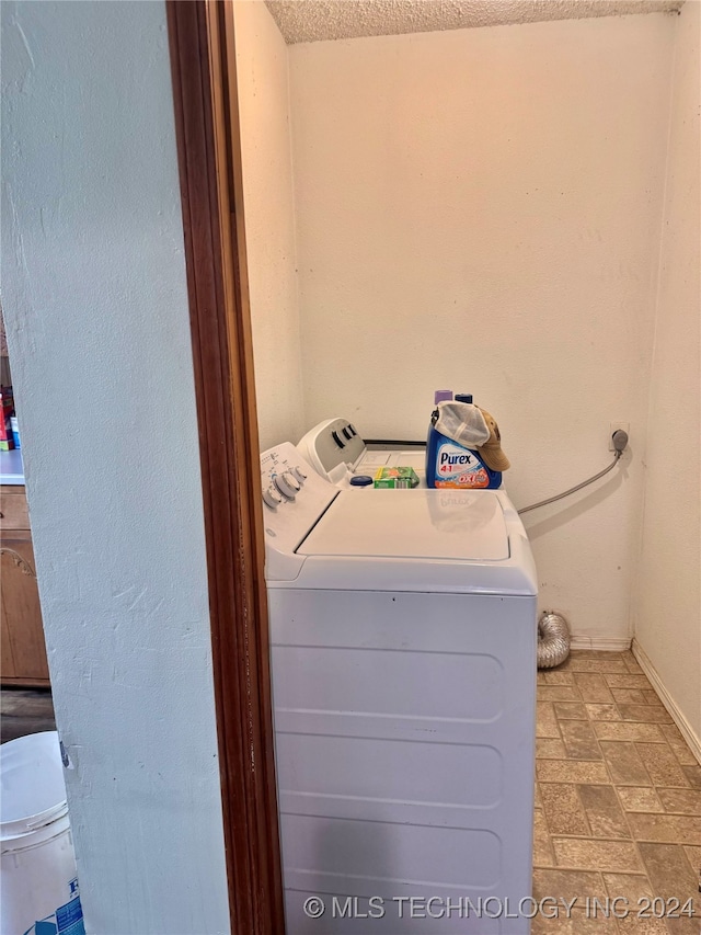 laundry room with separate washer and dryer and a textured ceiling