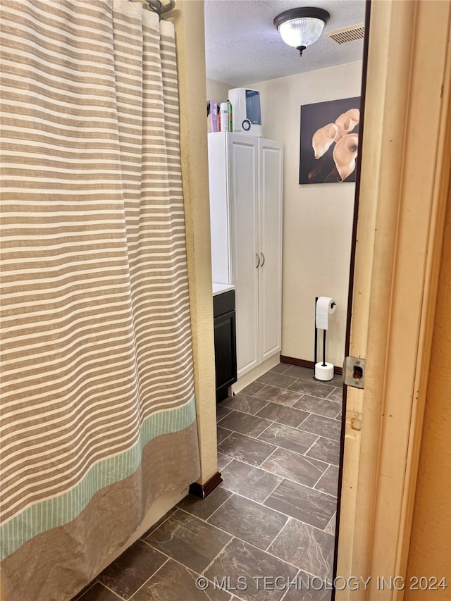 bathroom with vanity, a textured ceiling, and a shower with curtain