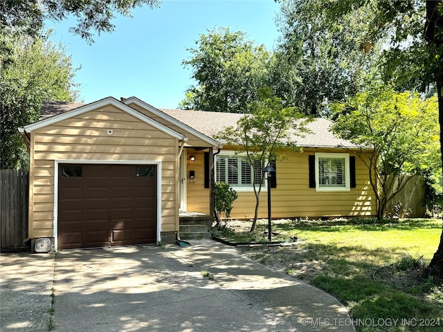 ranch-style house with a garage and a front lawn