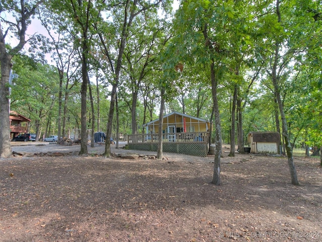 view of yard with a garage, a wooden deck, and an outdoor structure