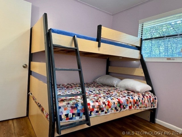 bedroom featuring baseboards and wood finished floors