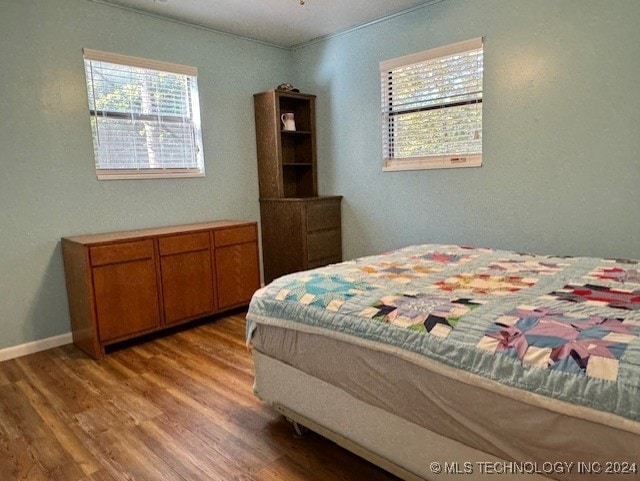 bedroom featuring baseboards and wood finished floors