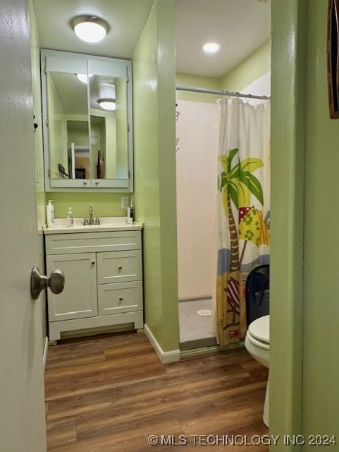 full bath with vanity, wood finished floors, baseboards, curtained shower, and toilet