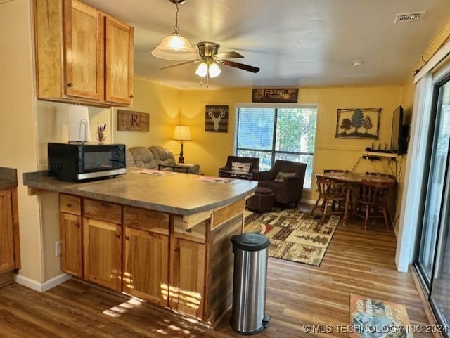 kitchen with dark wood-type flooring, a ceiling fan, and open floor plan