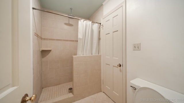 bathroom with toilet, tile patterned floors, and curtained shower