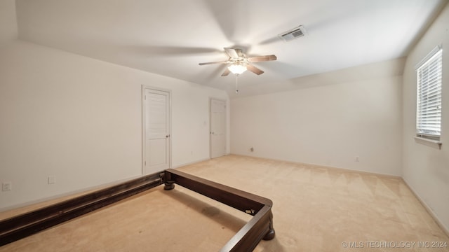 unfurnished bedroom featuring light carpet and ceiling fan