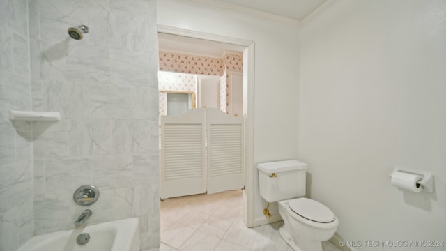 bathroom featuring toilet, ornamental molding, and tiled shower / bath