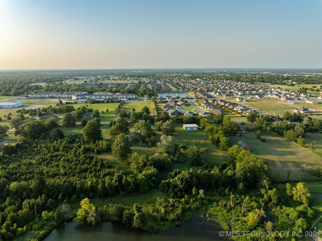 aerial view at dusk featuring a water view