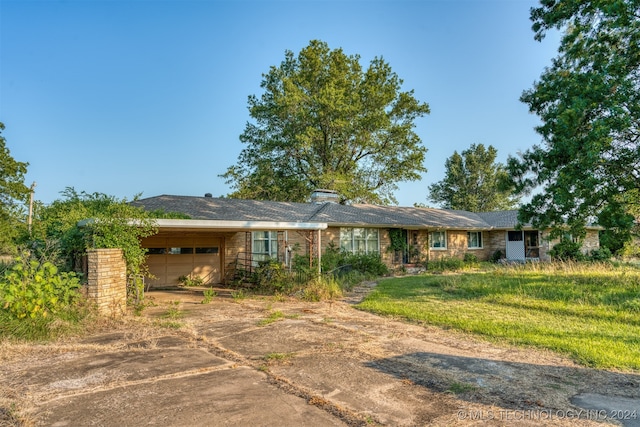 single story home with a garage and a front lawn