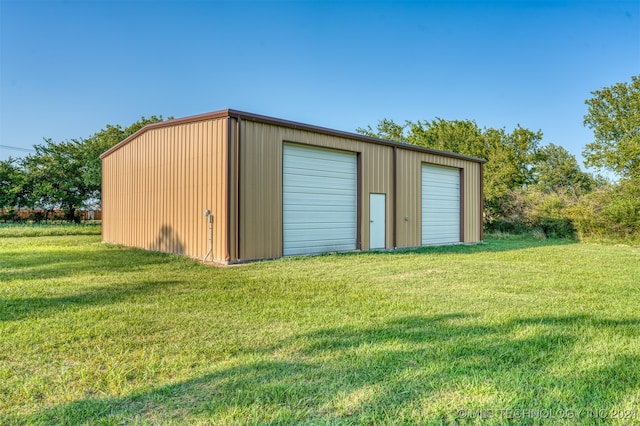 view of outbuilding with a garage and a yard